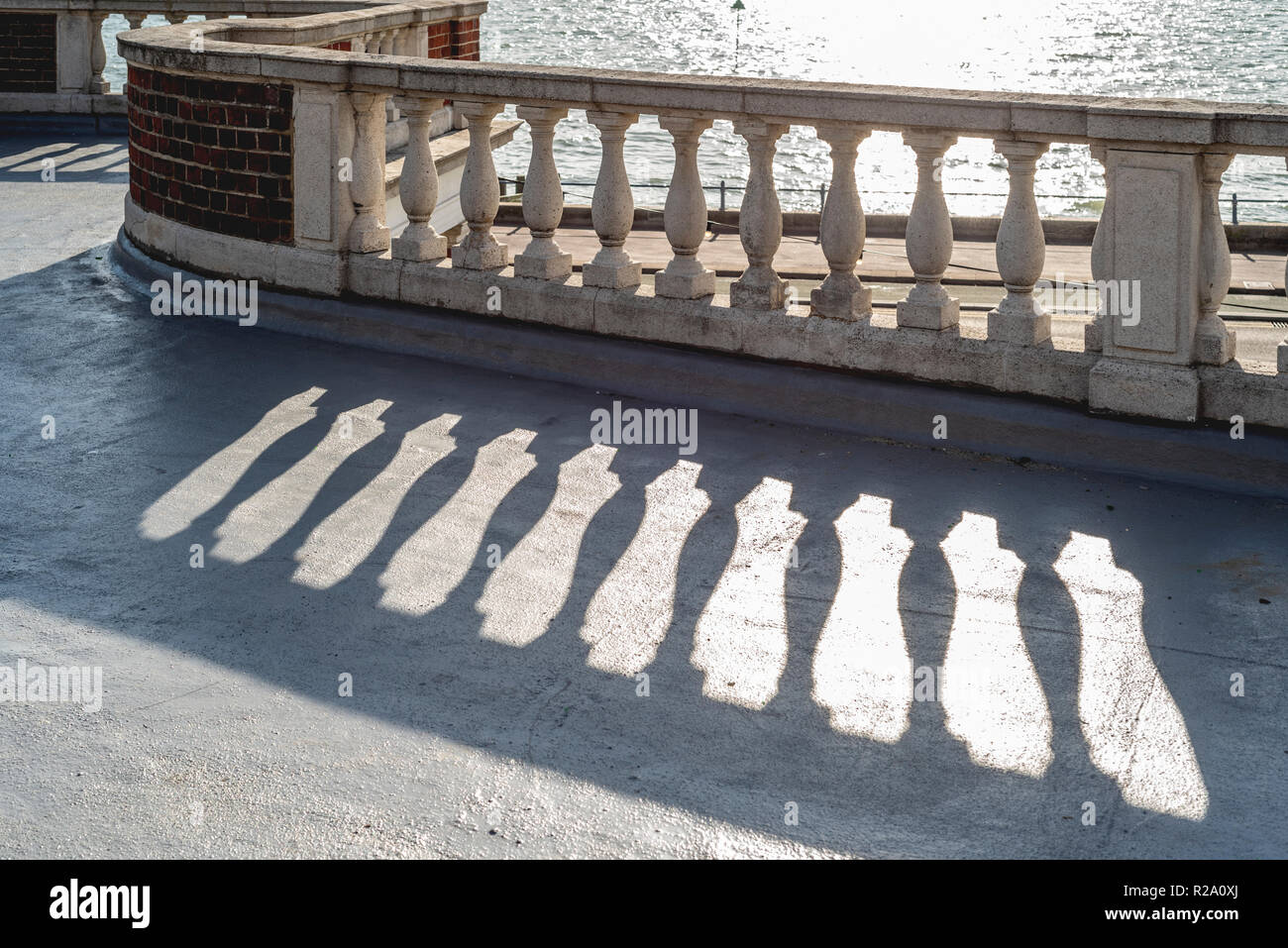 Vintage curved stone balustrade, with stone capping and red brickwork. Stock Photo