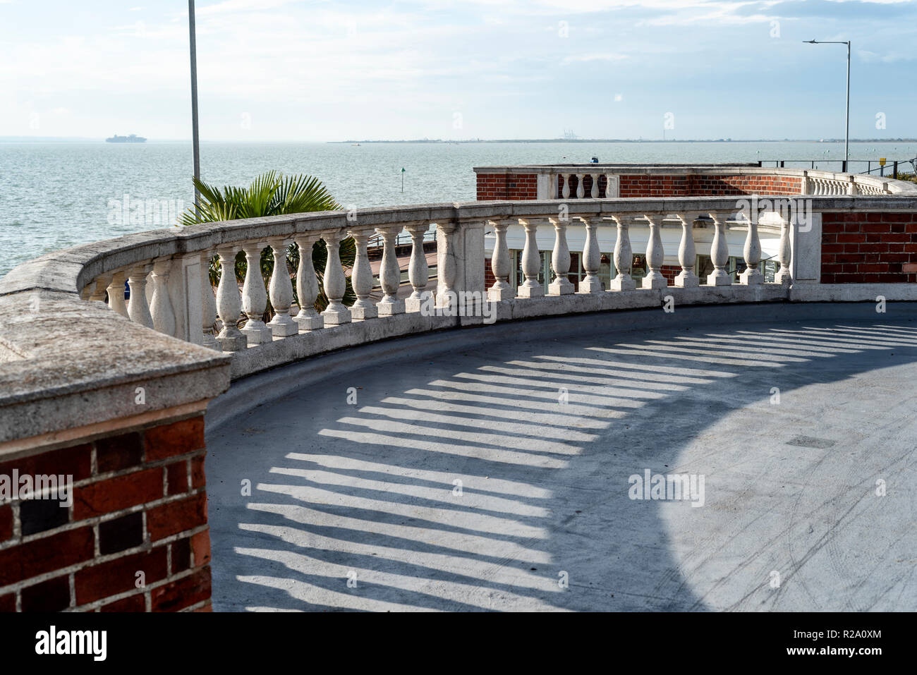 Vintage curved stone balustrade, with stone capping and red brickwork. Stock Photo