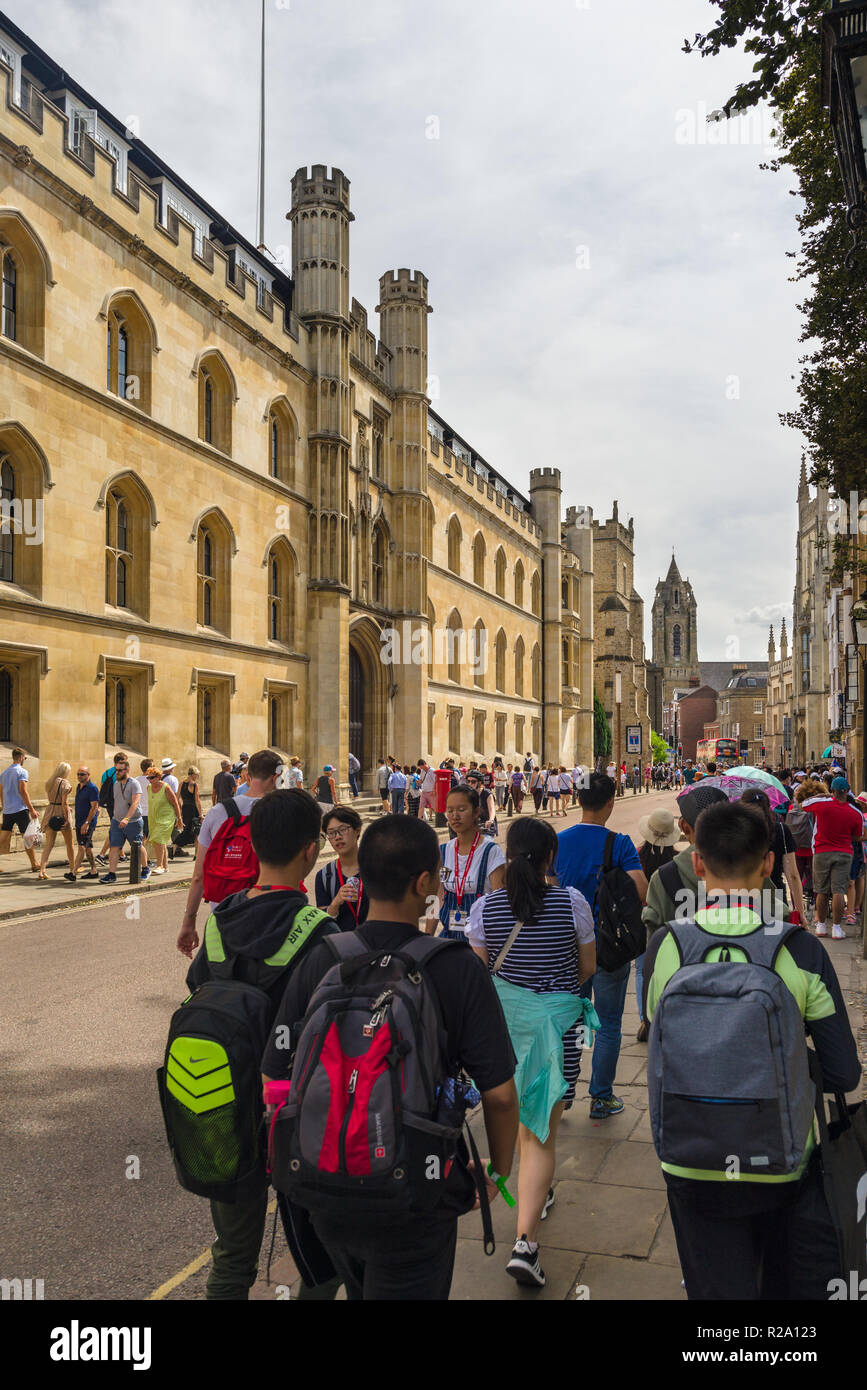 Exterior of Corpus Christi College from Trumpington Street with Asian tourists walking on pavement outside, Cambridge, UK Stock Photo