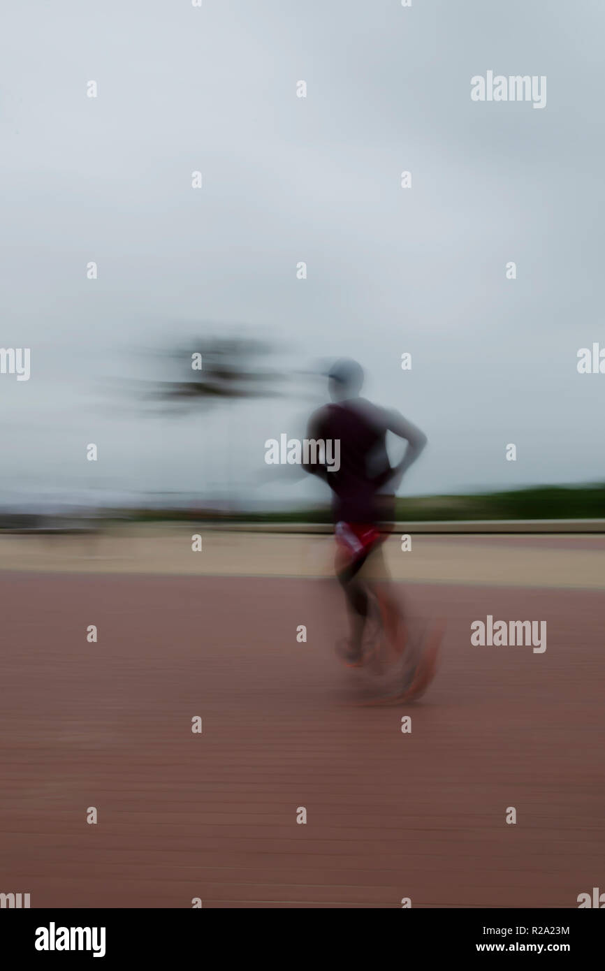 An early morning jogger puts in some hard work on Durban's beachfront boardwalk to keep himself in shape. Stock Photo