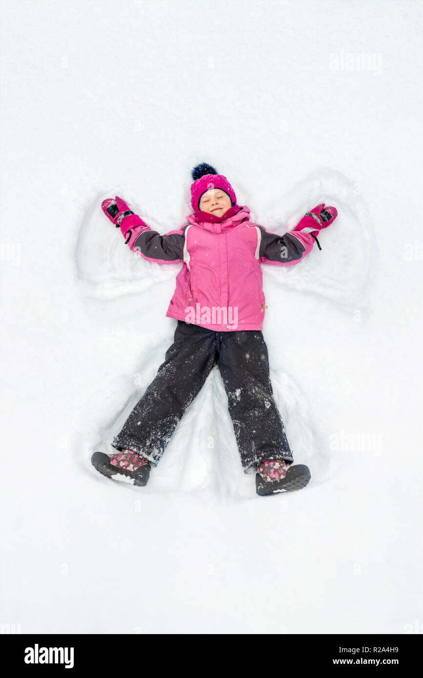 winter outdoor activities kids on Cute Little Kid Girl In Warm Ski Sport Suit Making Snow Angel Outdoors Kid Having Fun