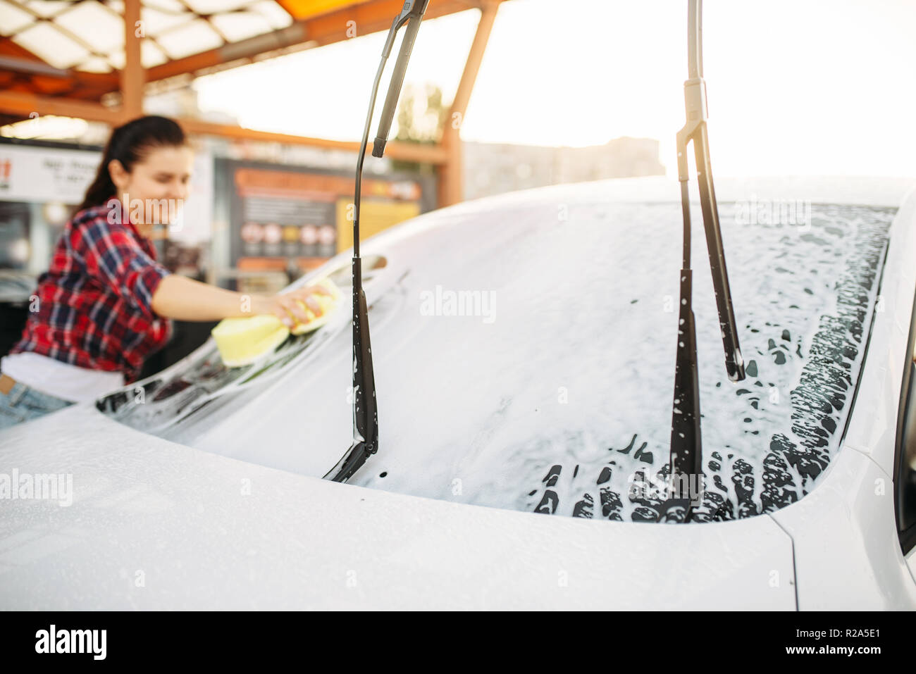 Cute woman with sponge scrubbing vehicle wheel with foam, car wash. Lady on  self-service automobile washing. Outdoor carwash at summer day Stock Photo  - Alamy