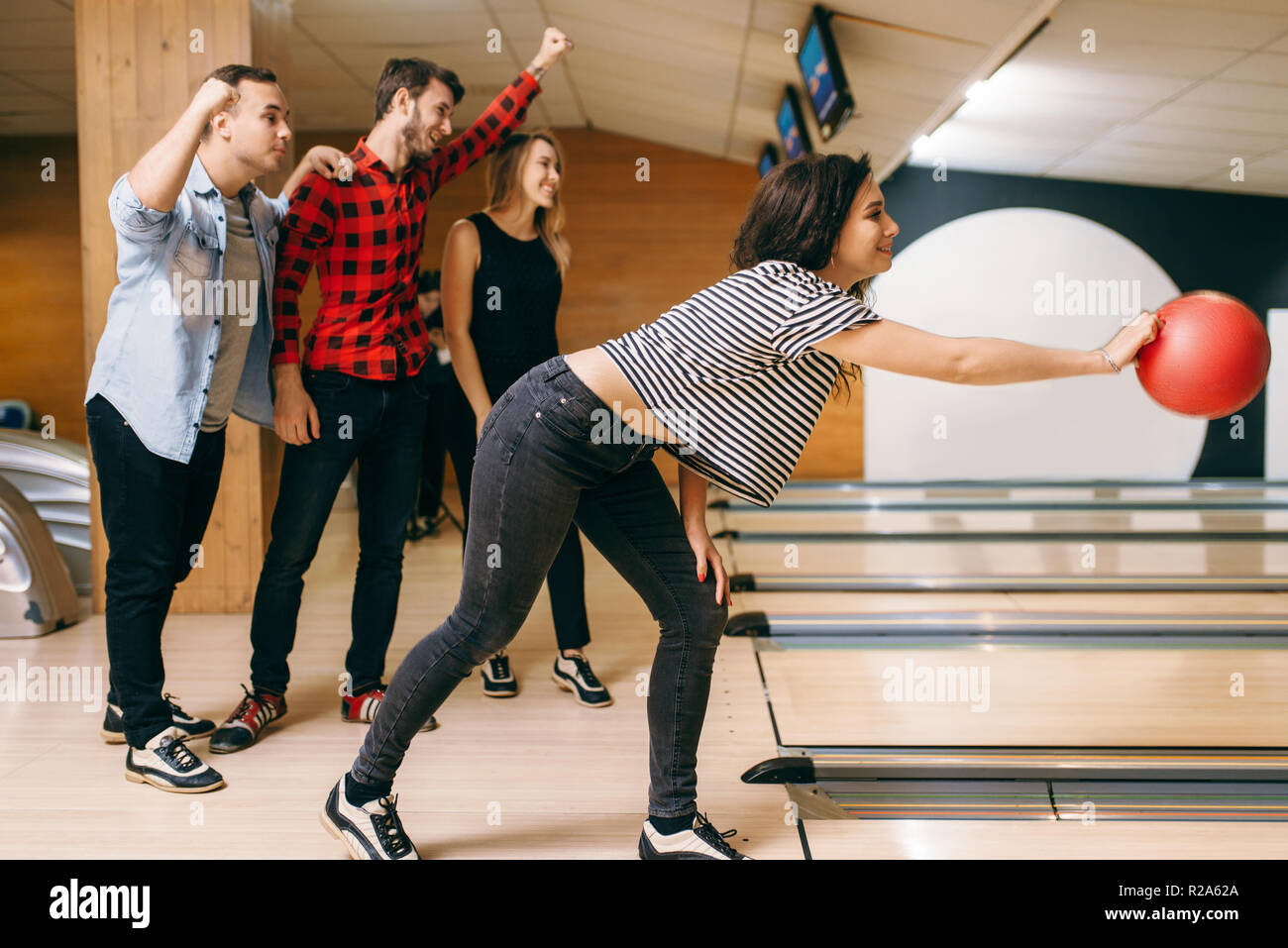 Female bowler on lane, ball throwing in action, strike shot preparation