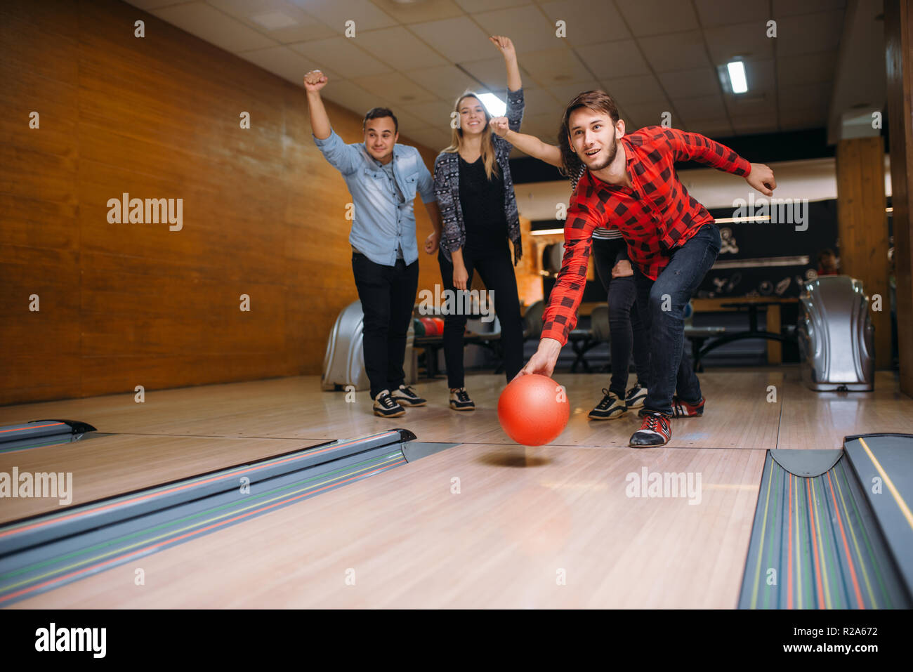 Male bowler throws ball on lane, strike shot. Bowling alley teams