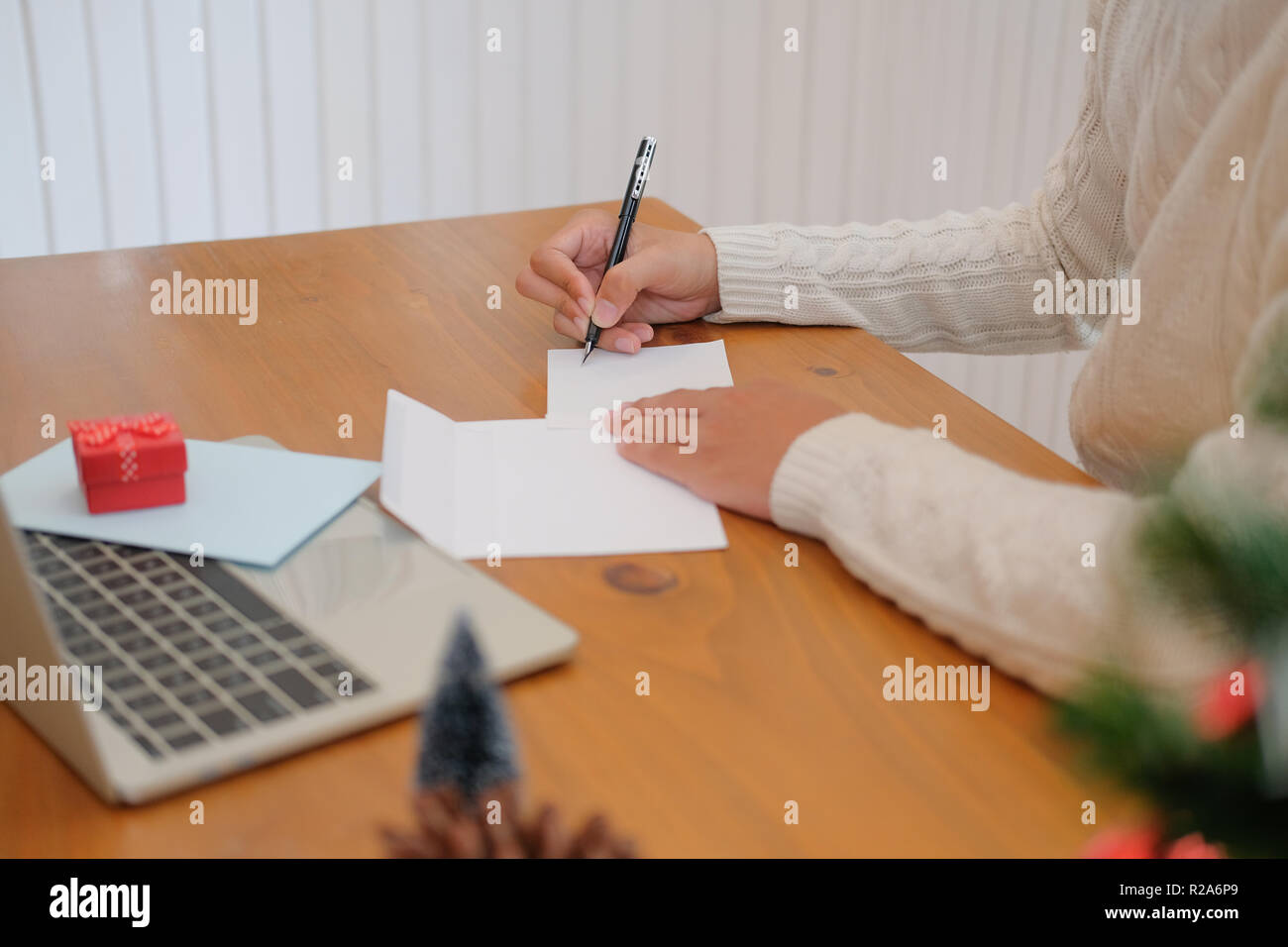 man wearing cream sweater writing christmas letter greeting card ...