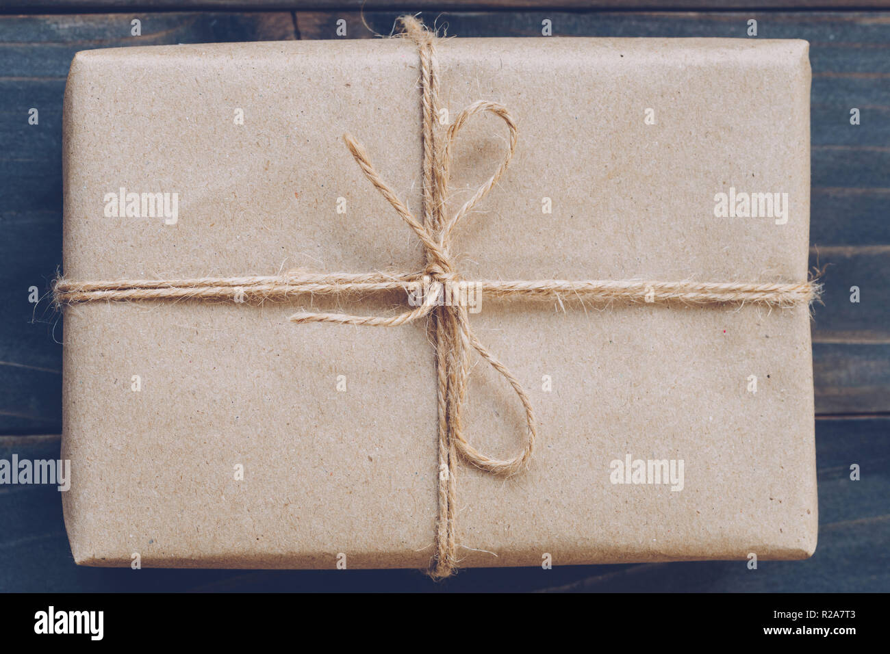 String or twine tied in a bow on kraft paper gift box texture Stock