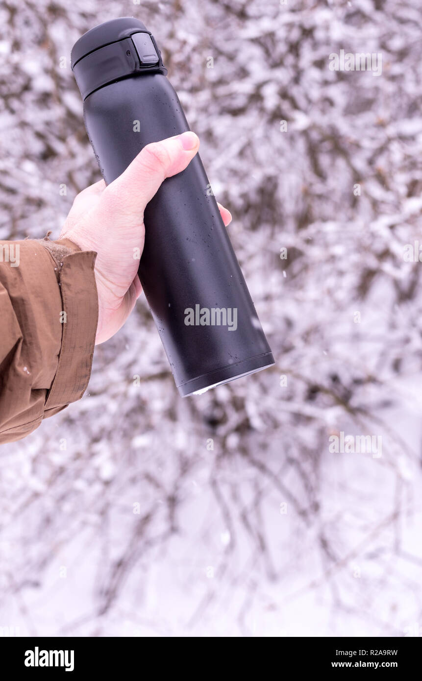 AMan hold vacuum insulated bottles. Keeping drinks hot. Stock Photo