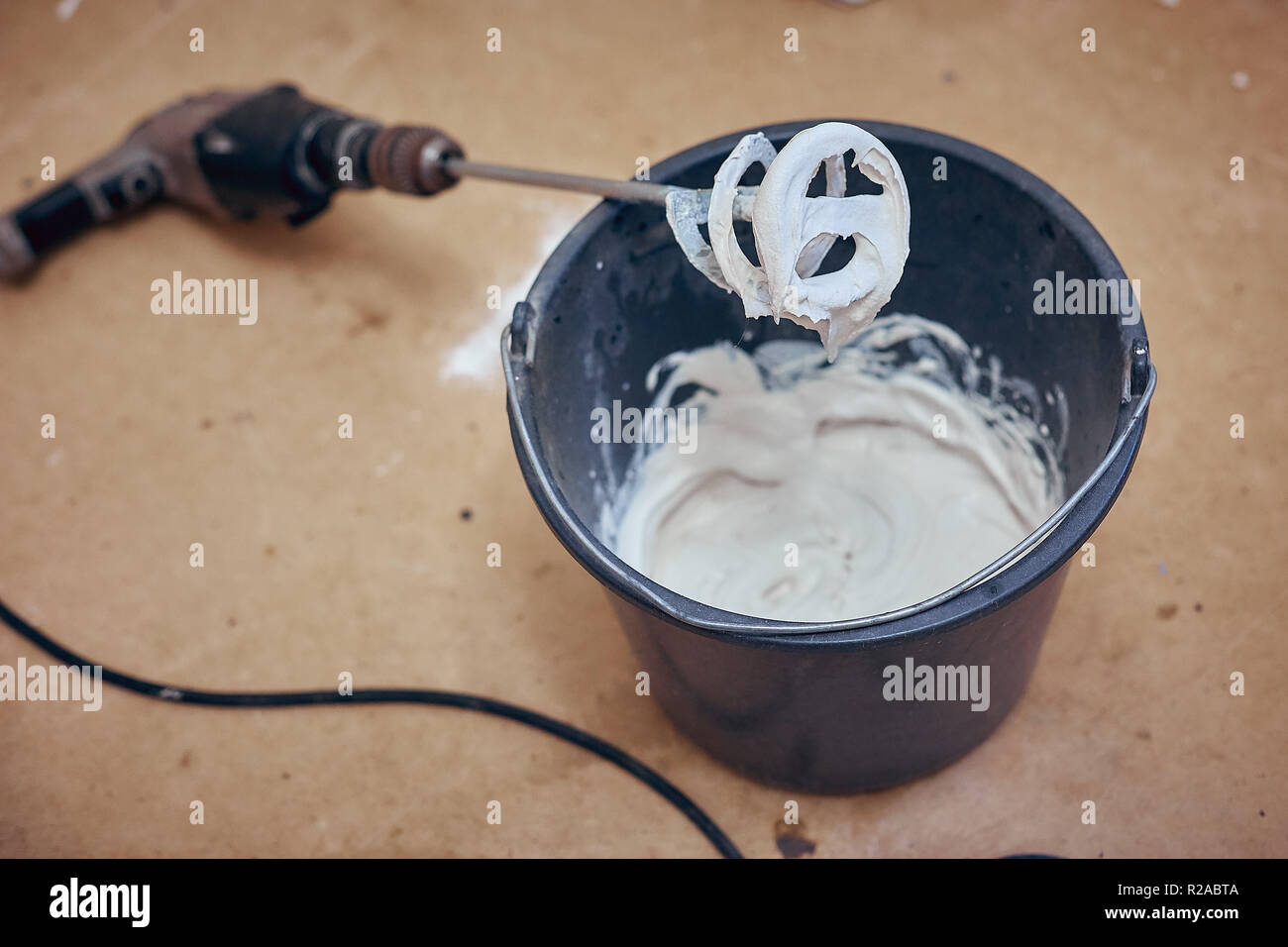 a bucket of ready construction with plaster walls, a mixer for mixing