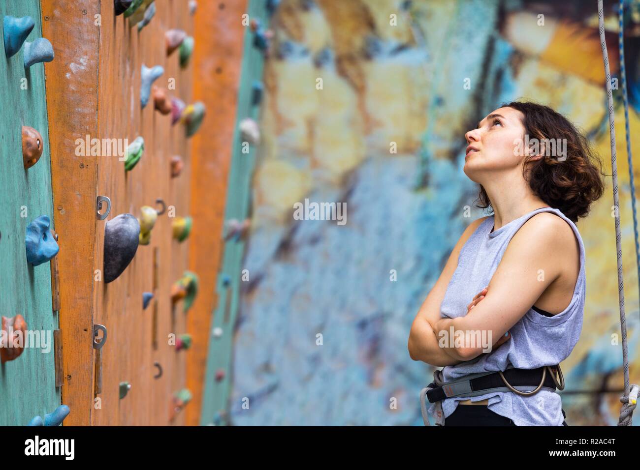 Bouldering, beautiful girl look on the climbing wall. Assessment