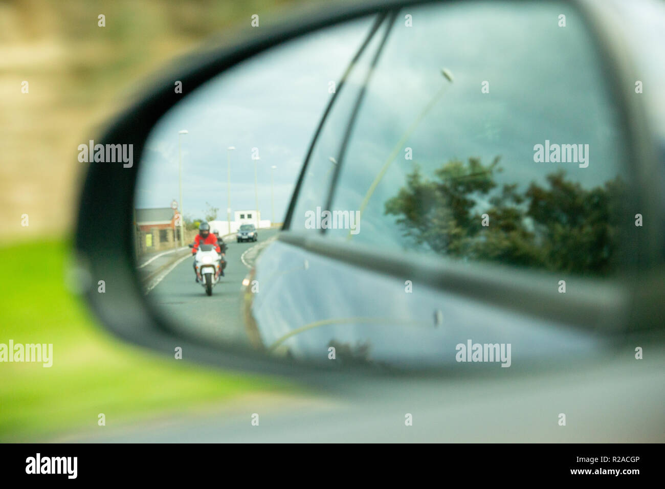 Biker in car mirror. Think Bike Stock Photo
