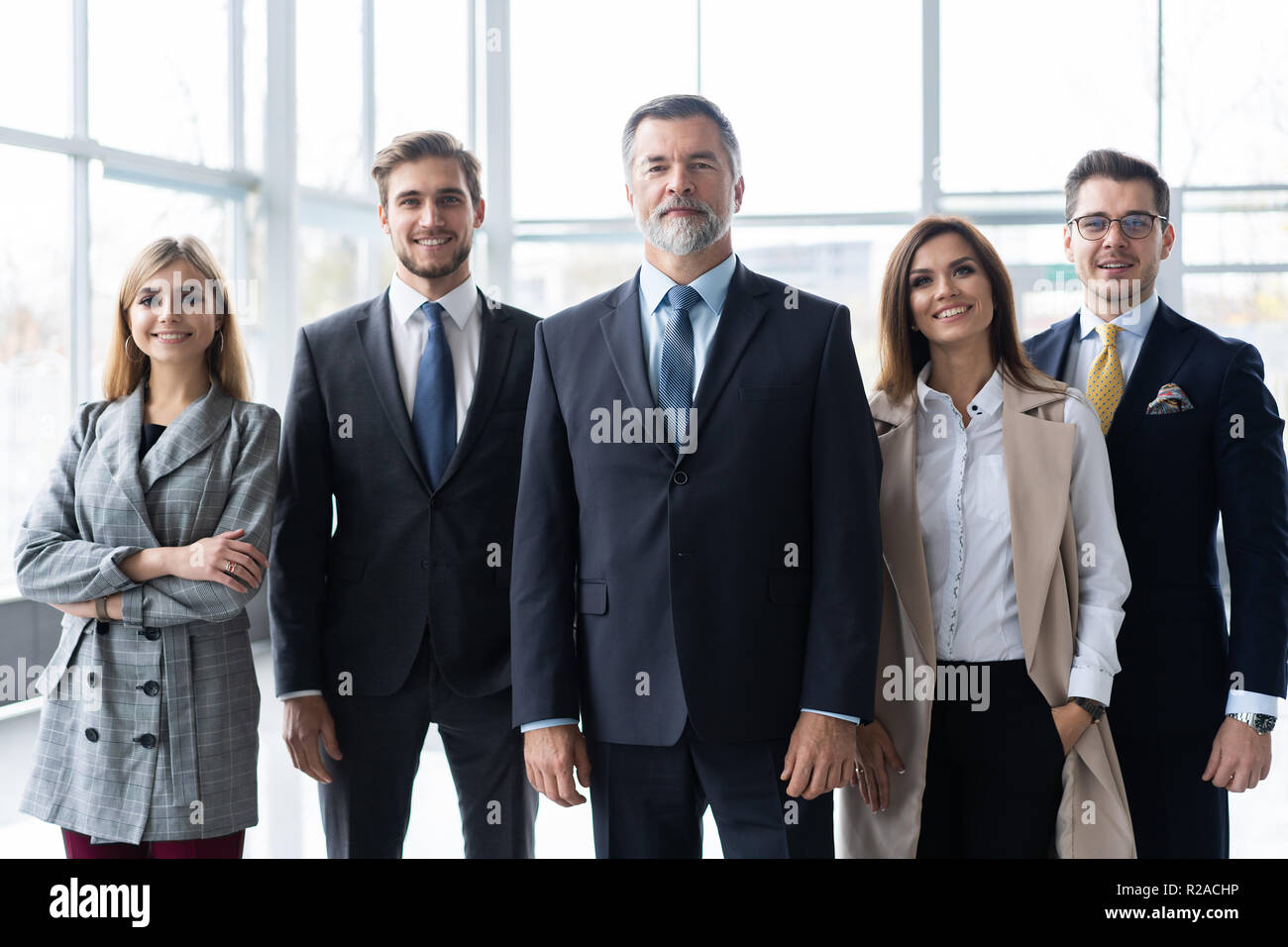 Happy business team with arms crossed at the office Stock Photo - Alamy