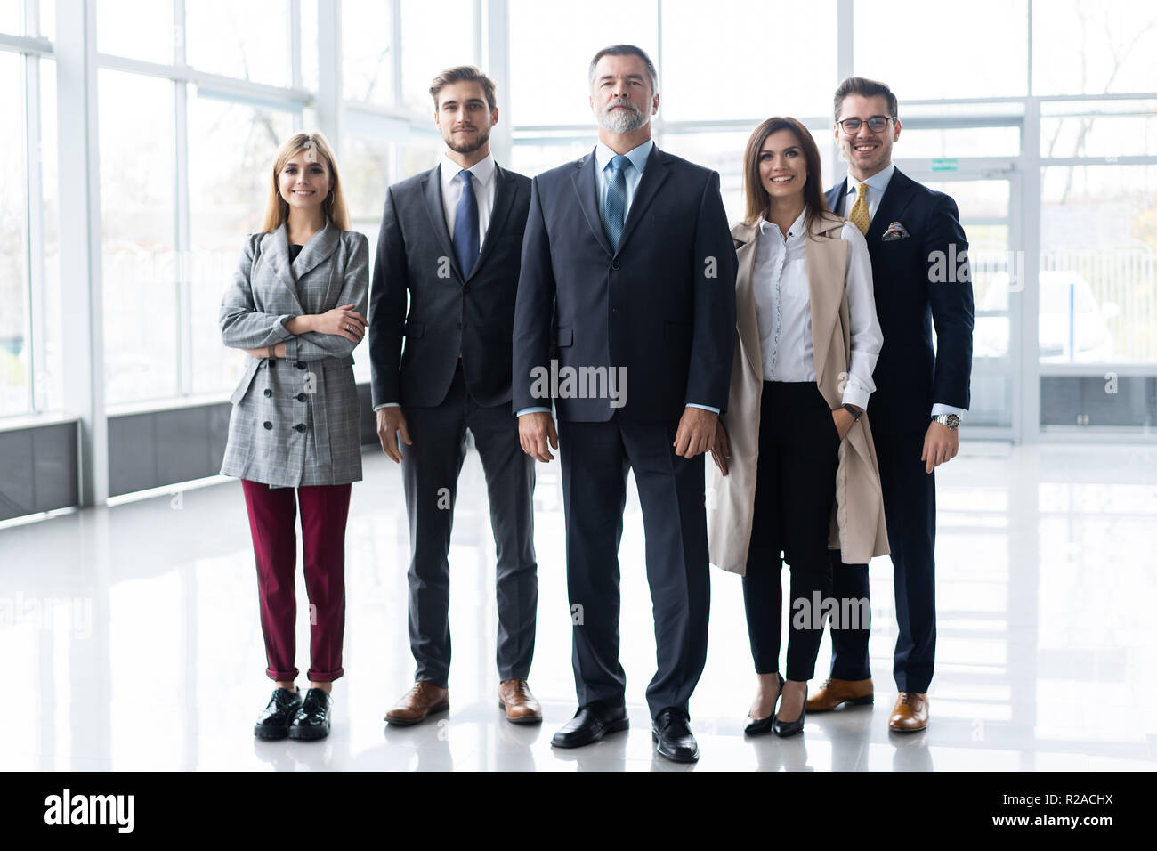 Happy business team with arms crossed at the office Stock Photo - Alamy