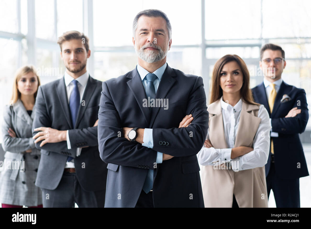 Happy business team with arms crossed at the office Stock Photo - Alamy