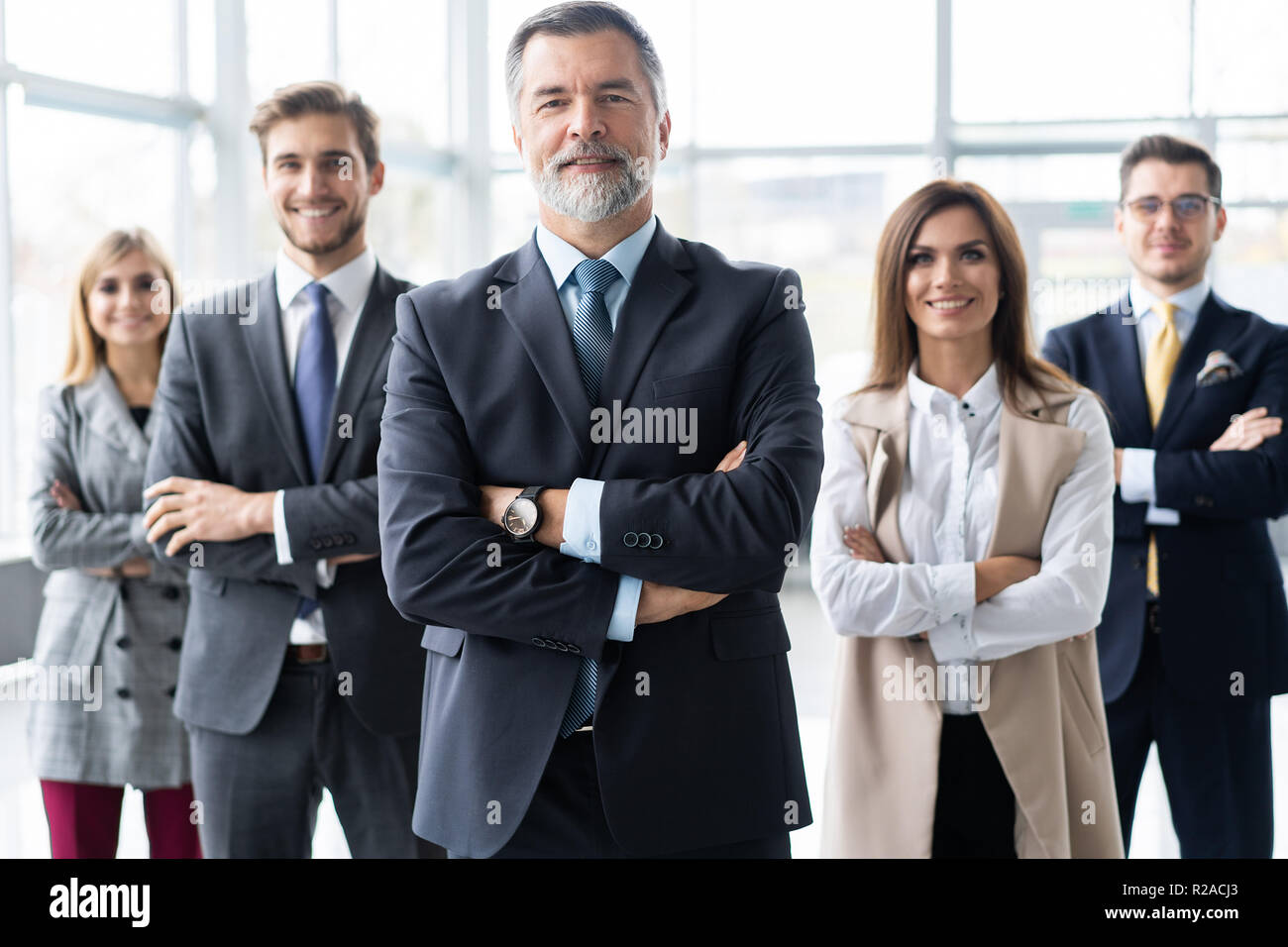 Happy business team with arms crossed at the office Stock Photo - Alamy