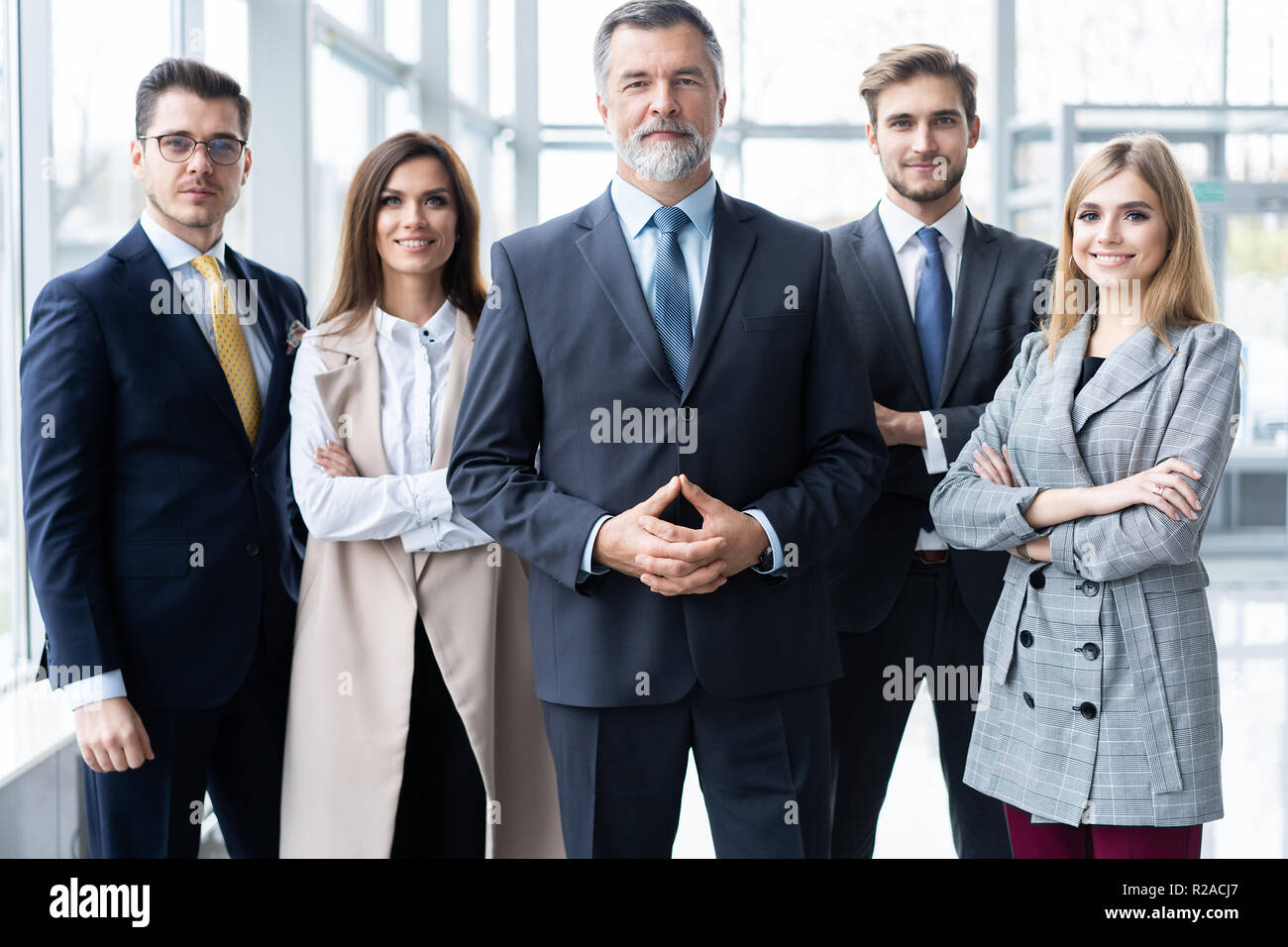 Happy business team with arms crossed at the office Stock Photo - Alamy