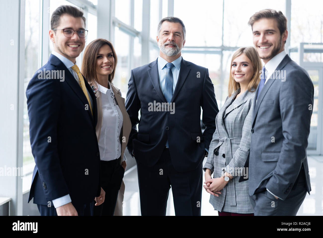 Happy business team with arms crossed at the office Stock Photo - Alamy