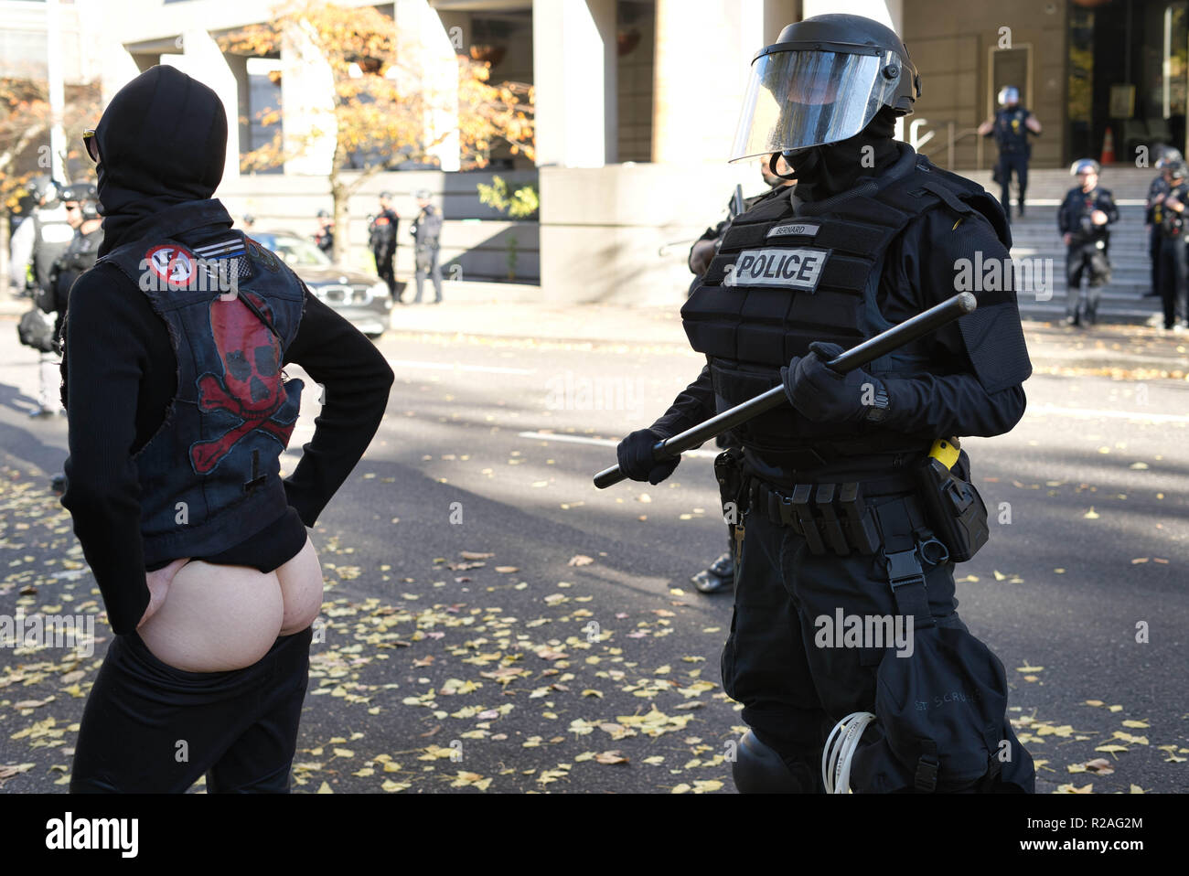 Rose City Antifa protestor moons a riot cop during the counter protest. Stock Photo