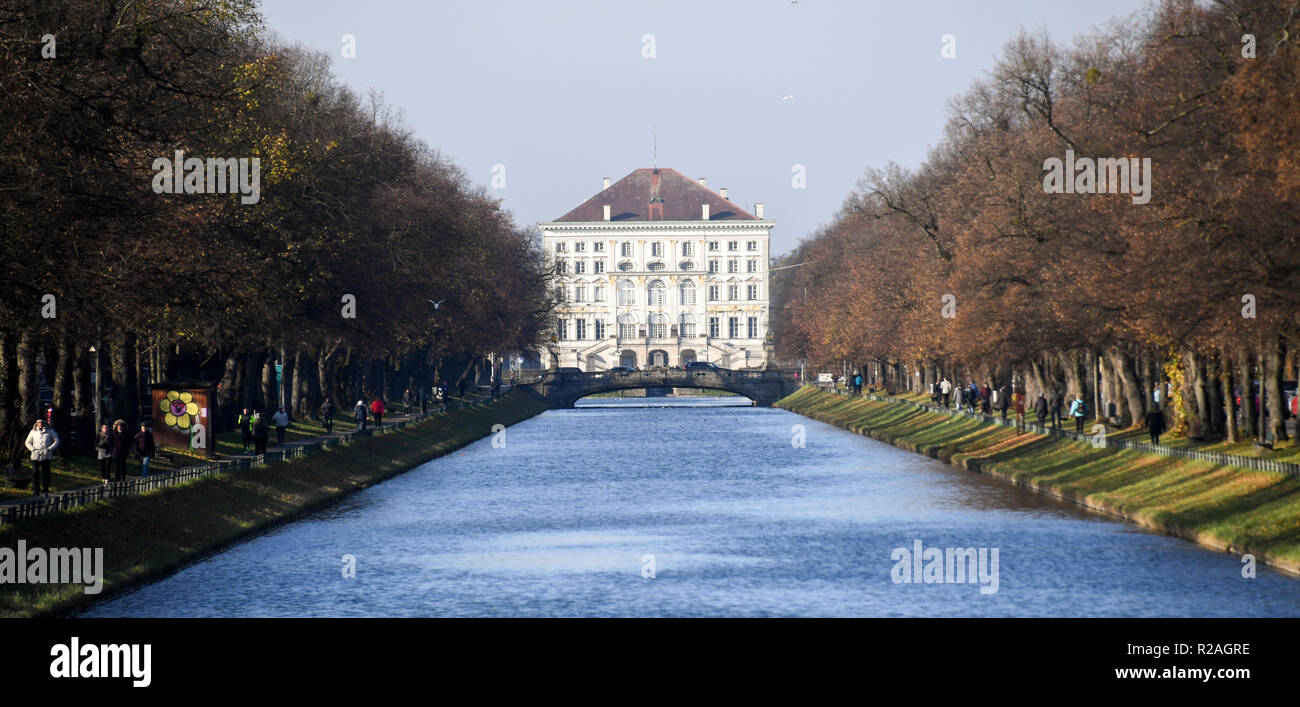 18 November 2018, Bavaria, München: Walkers stroll along the paths along the Nymphenburger Kanal. In the background stands Nymphenburg Castle. Photo: Tobias Hase/dpa Stock Photo