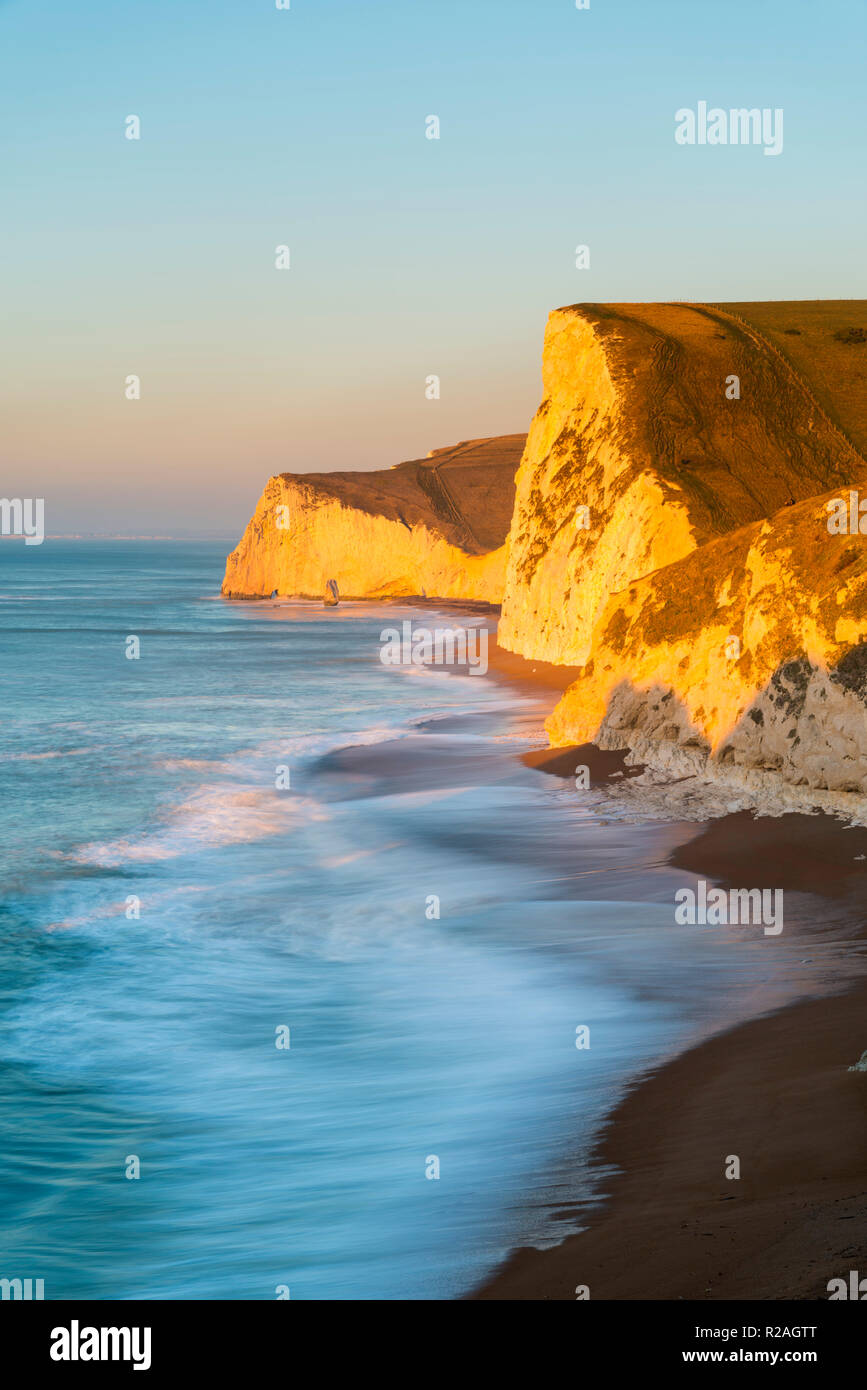 Lulworth, Dorset, UK.  18th November 2018.  The chalk cliffs of Swyre Head and Bats Head on the Jurassic Coast of Dorset near Lulworth glow in the early morning golden sunlight shortly after sunrise on a cold clear day.  Picture Credit: Graham Hunt/Alamy Live News. Stock Photo