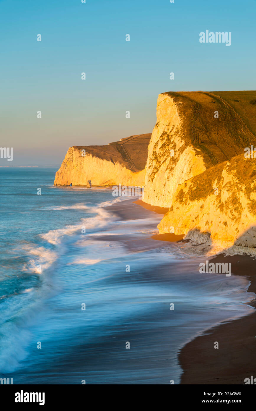 Lulworth, Dorset, UK.  18th November 2018.  The chalk cliffs of Swyre Head and Bats Head on the Jurassic Coast of Dorset near Lulworth glow in the early morning golden sunlight shortly after sunrise on a cold clear day.  Picture Credit: Graham Hunt/Alamy Live News. Stock Photo