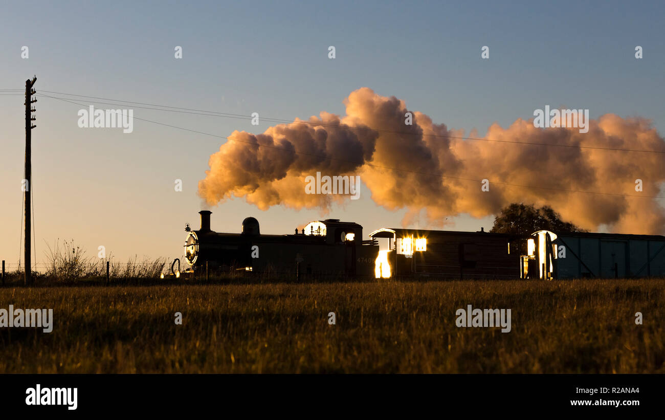 Leicestershire, UK. 18th November 2018. 0-6-0T Jinty steam locomotive, No. 47406 hauls a freight train during sunset on the Great Central Railway, Quorn & Woodhouse, Loughborough, Leicestershire, UK. 18th November 2018. Photograph by Richard Holmes. Credit: Richard Holmes/Alamy Live News Stock Photo