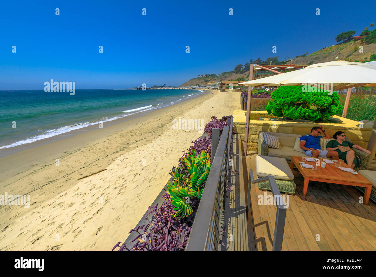 Malibu, California, United States - August 7, 2018: couple sitting at luxurious Japanese restaurant Nobu on famous Billionaire Beach or Carbon Beach for many famous people in Malibu. Summer holidays. Stock Photo