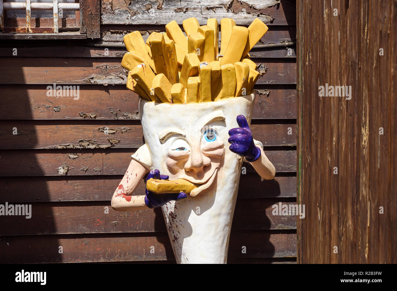 Milan , Italy 17 July 2018 : an abandoned statue that represents the advertising of a fries shop . French fries mascots are the favorite side dish and they pair on many hamburgers Stock Photo