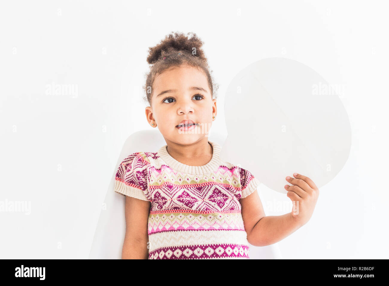 Portrait of a little girl in a colorful dress on a white background ...
