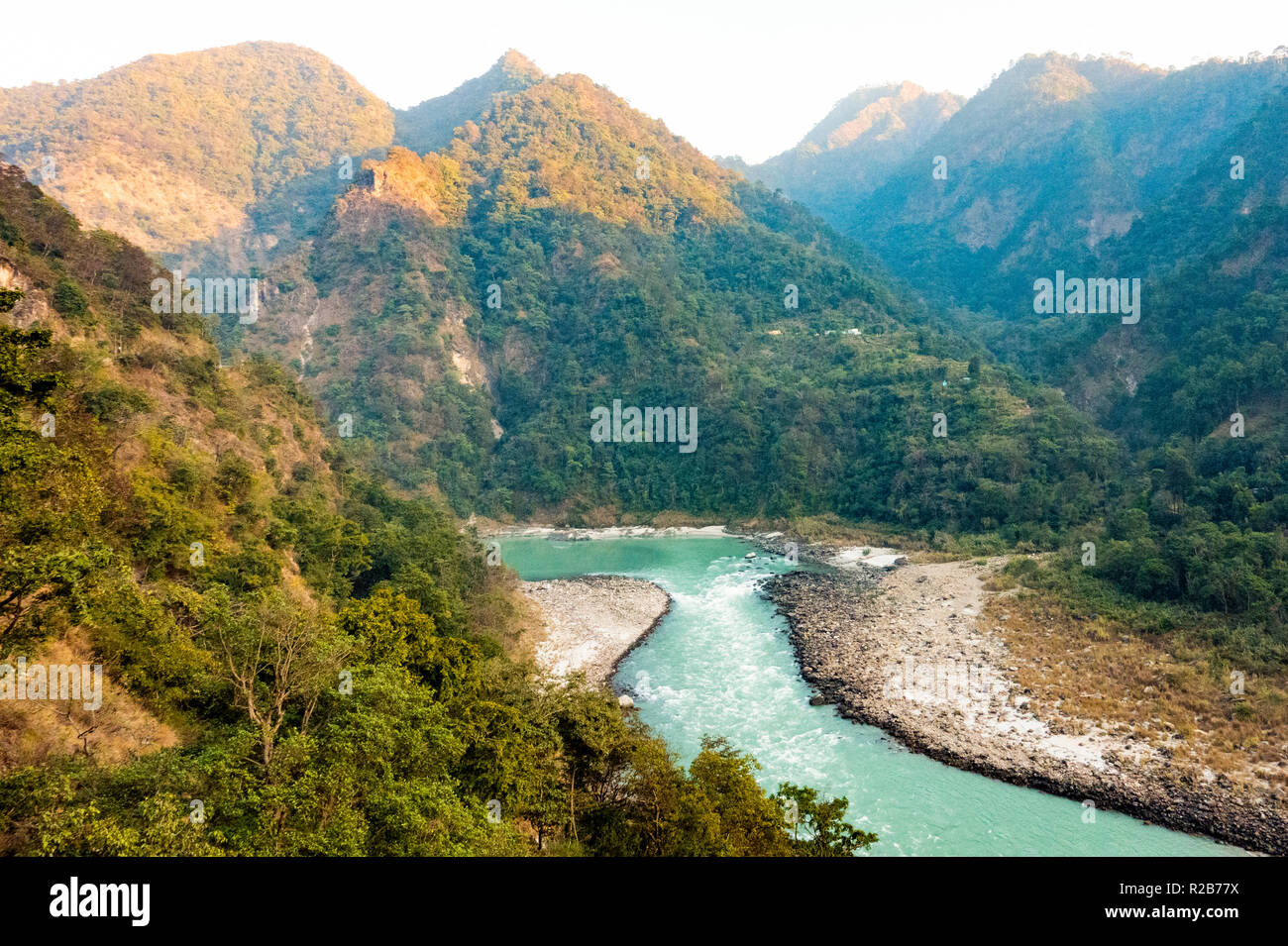 Spectacular view of the sacred Ganges river flowing through the green mountains of Rishikesh, Uttarakhand, India. Stock Photo