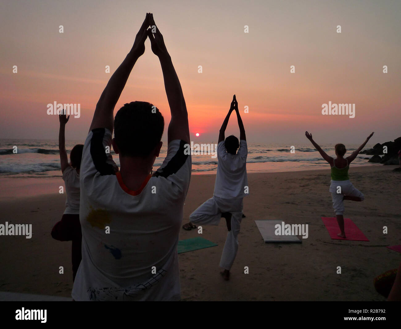 India, Kerala, Varkala, 01/31/2009: Yoga class on the Varkala beach at sunset Stock Photo