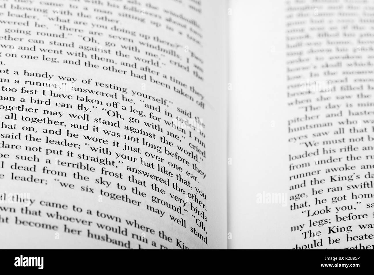 A book with English words lies open, showing portions of two pages with shallow focus and depth of field. Stock Photo