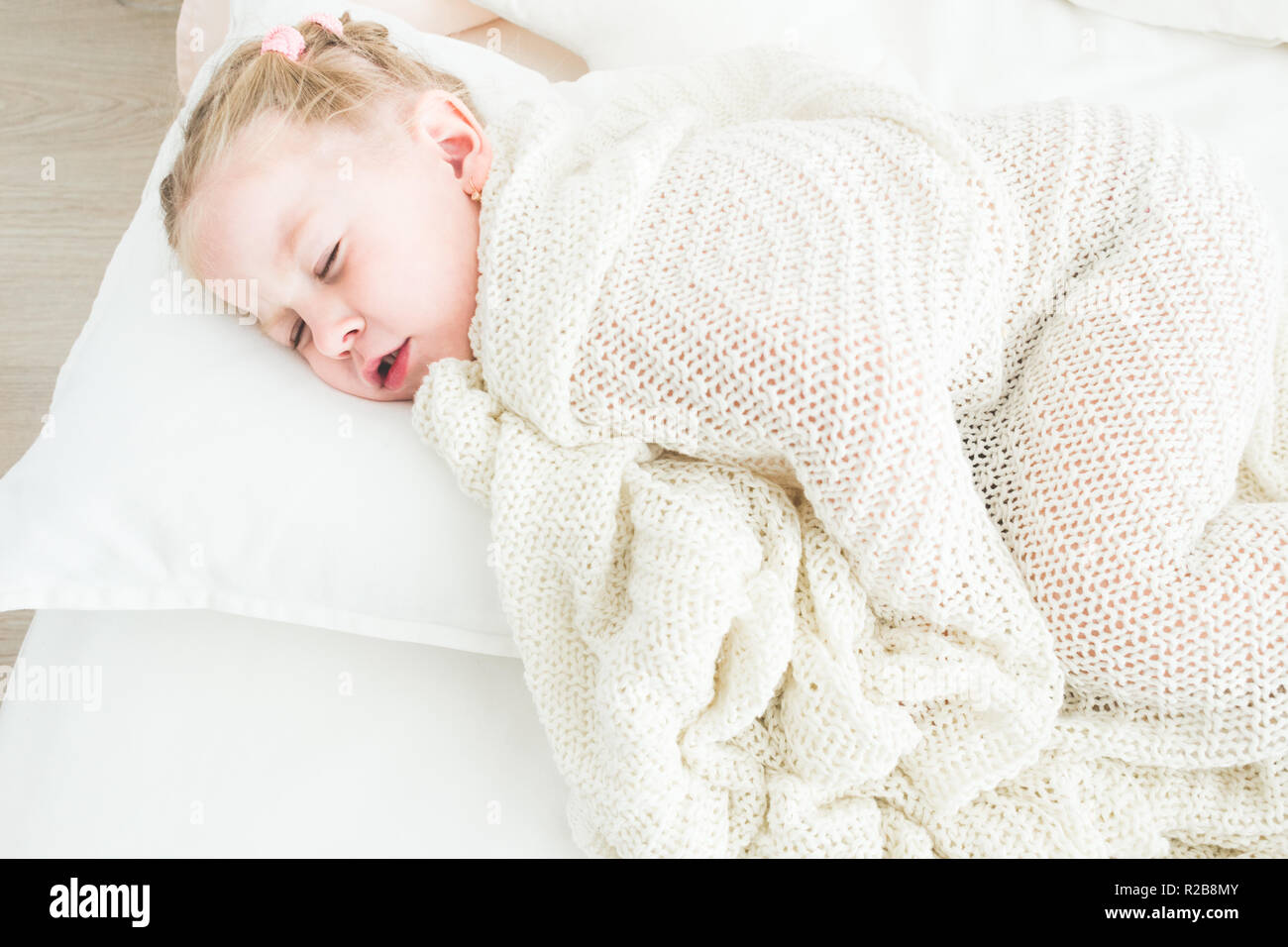 Cute little girl sleeping covered in white blanket Stock Photo - Alamy