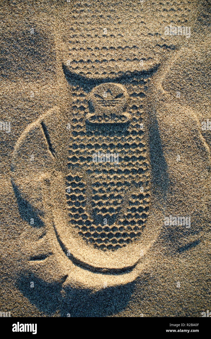 Adidas brand logo shoe footprint on the sand of a beach Stock Photo - Alamy