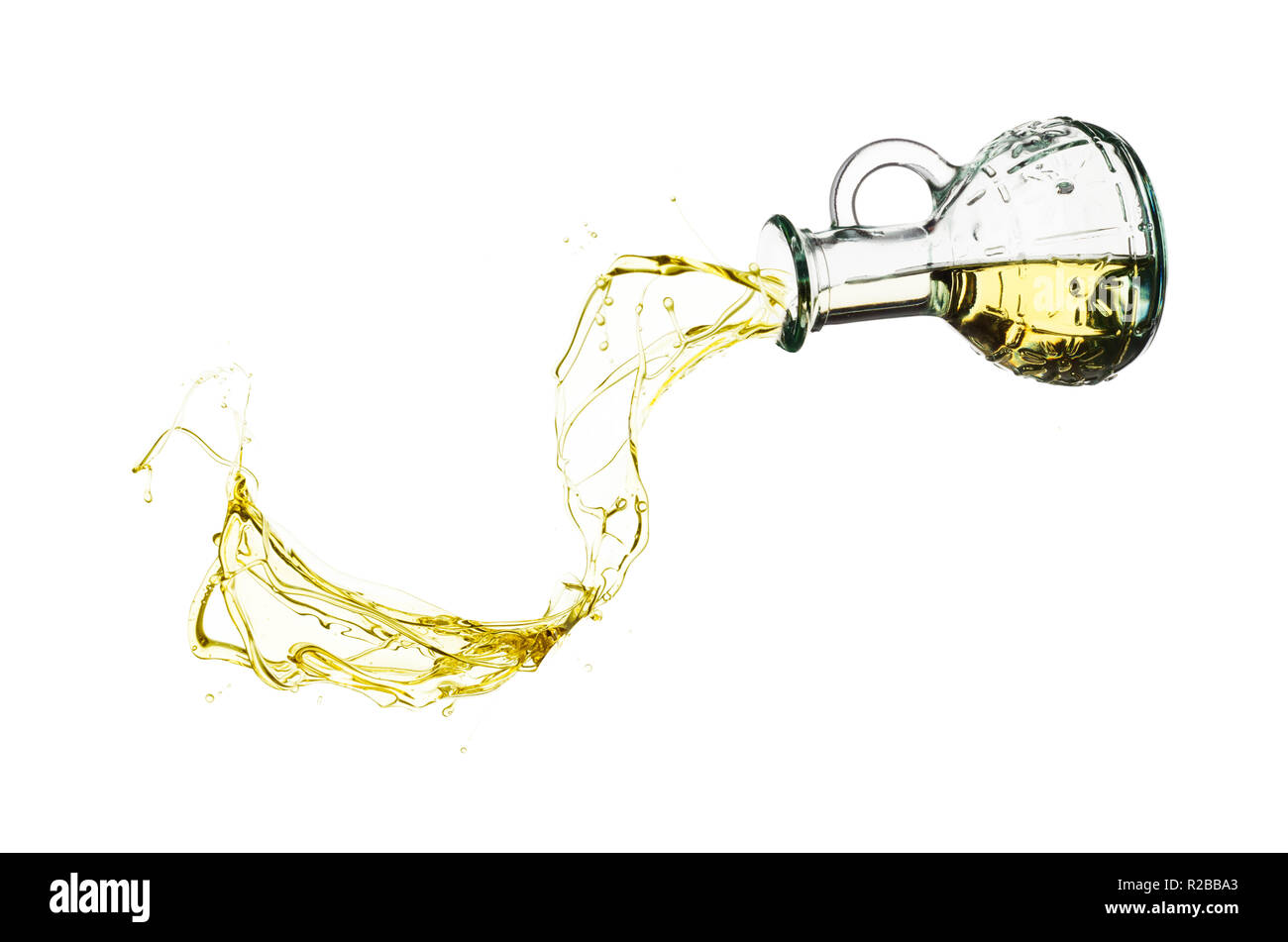 Olive oil pouring from glass bottle isolated against white background Stock Photo