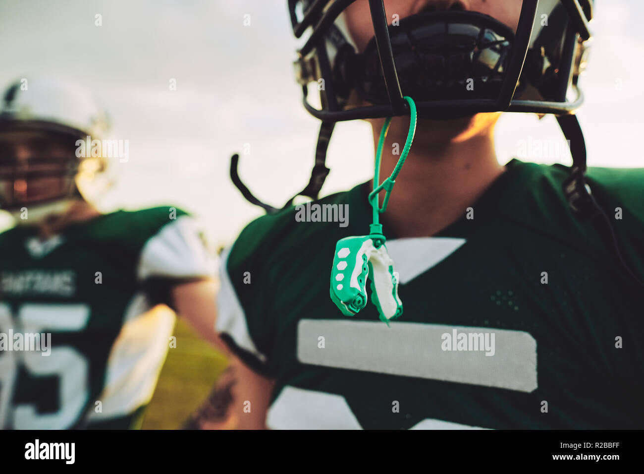 Closeup of a young American football player with his mouthguard hanging