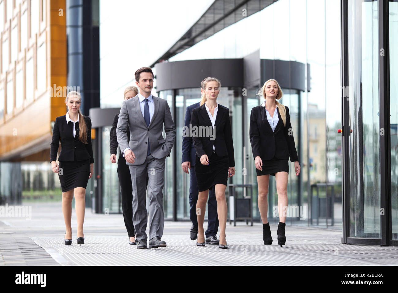 Portrait of successful business people team walking together outdoors near modern office building Stock Photo