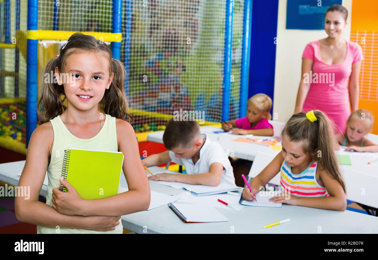 Portrait of cheerful diligent pupil girl studying in school class Stock ...