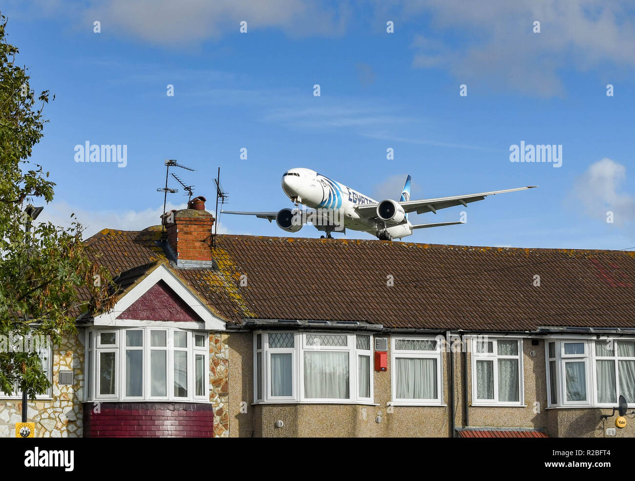 LONDON, ENGLAND - NOVEMBER 2018: Egyptair Boeing 777 jet flying low over rooftops to land at London Heathrow Airport. Stock Photo