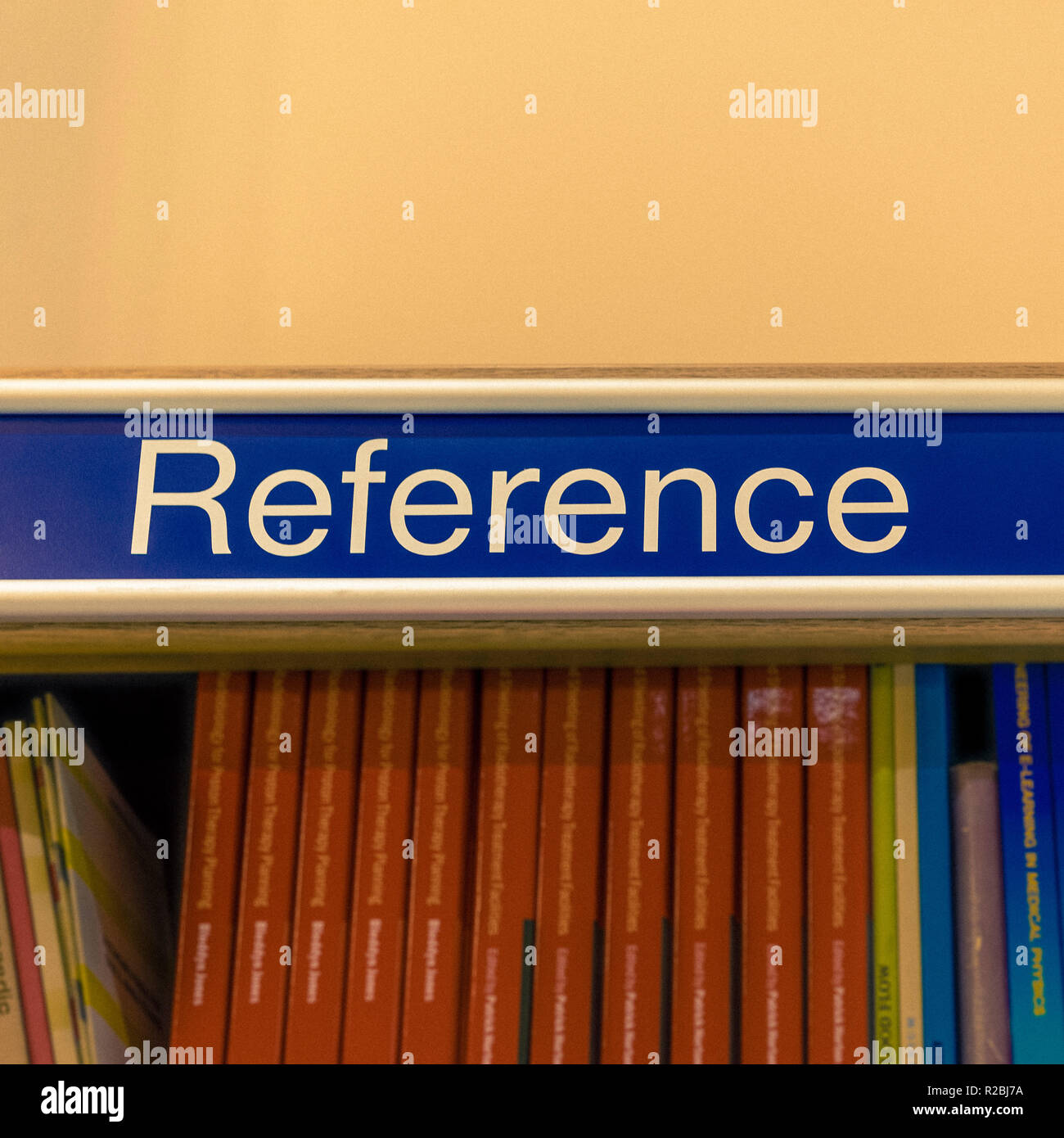 Reference sign above shelf full of books in library Stock Photo