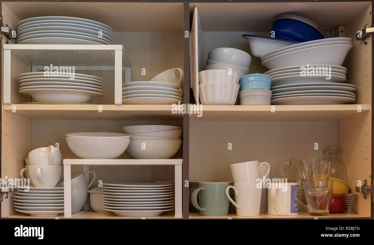 Domestic kitchen cupboards interior with stacked crockery Stock Photo