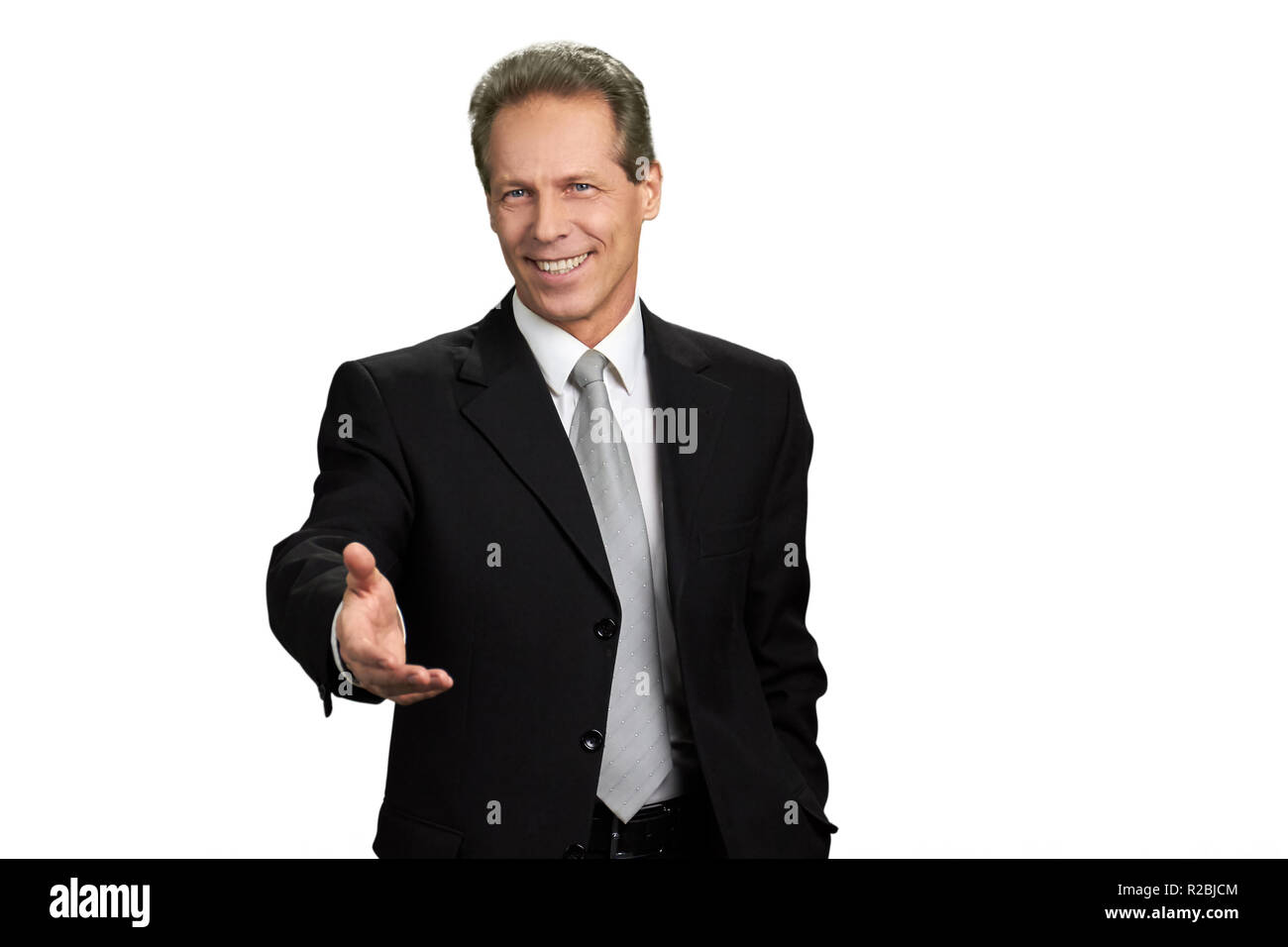 Businessman outstretched hand for greeting. Portrait of businessman extending hand for handshake, isolated on white background. Stock Photo