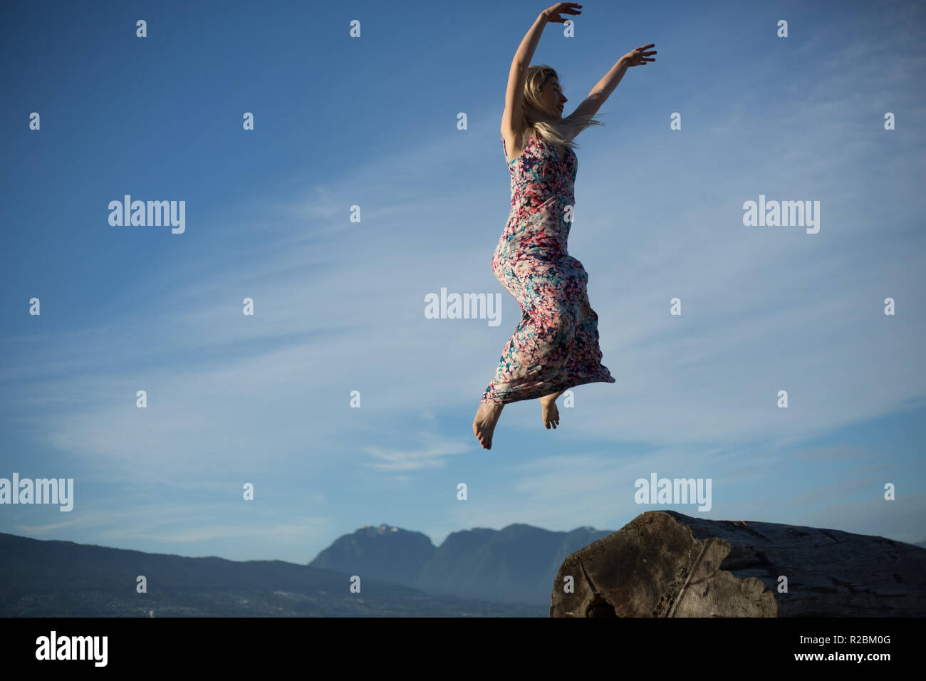 beautiful girl jumping air blue sky Stock Photo - Alamy