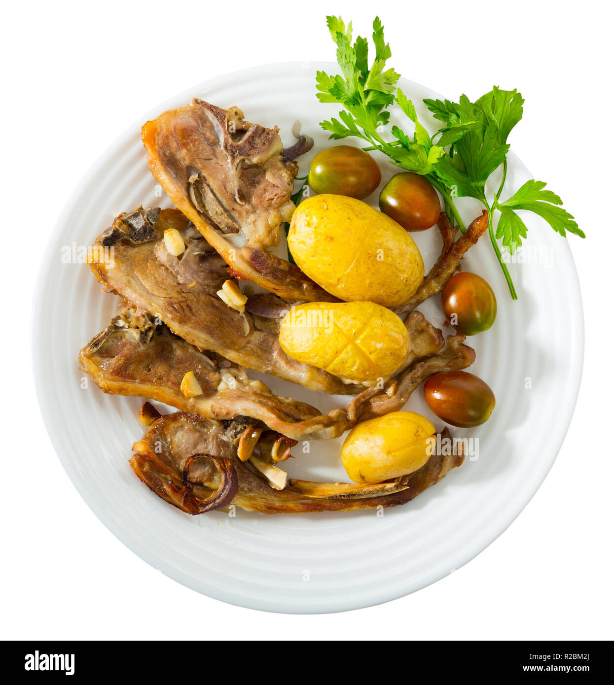 Slow cooked mouton ribs with potato, spanish plate Costillas de cordero. Isolated over white background Stock Photo