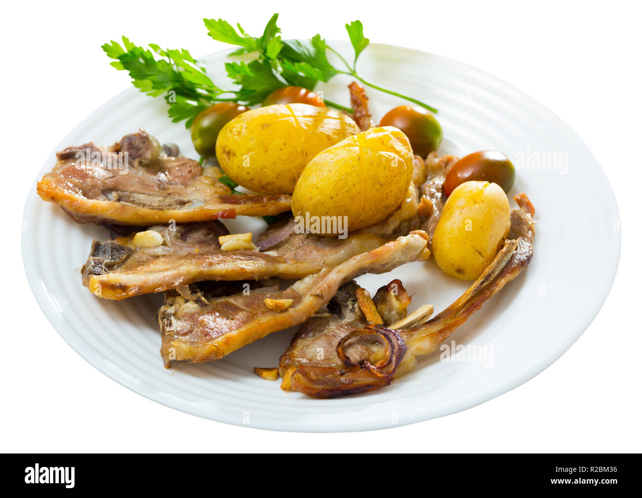 Traditional spanish dish Costillas de cordero, lamb with vegetables. Isolated over white background Stock Photo