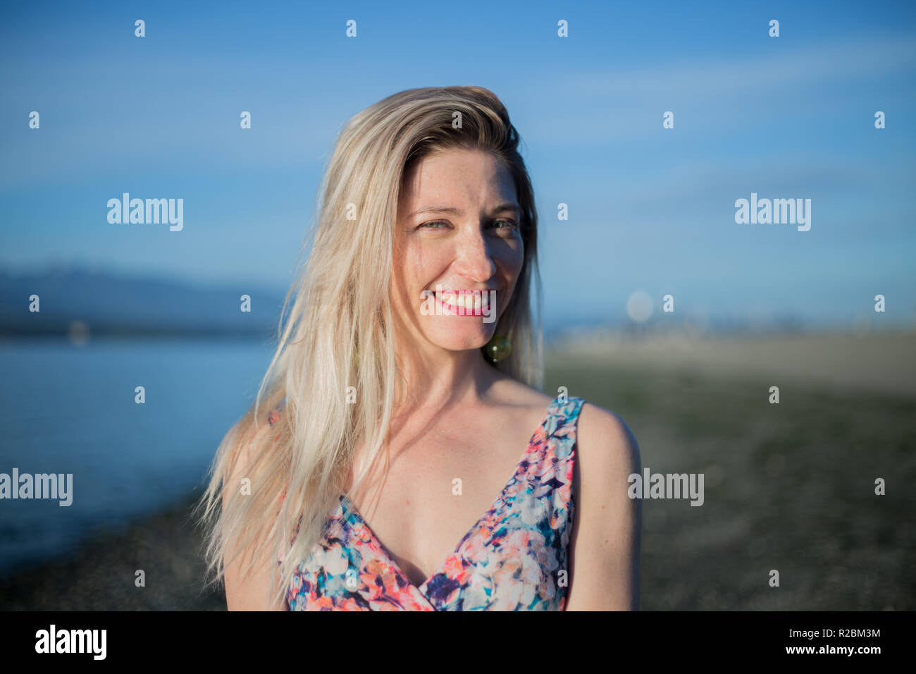 Smiling beautiful caucasian woman portrait sea blue sky Stock Photo