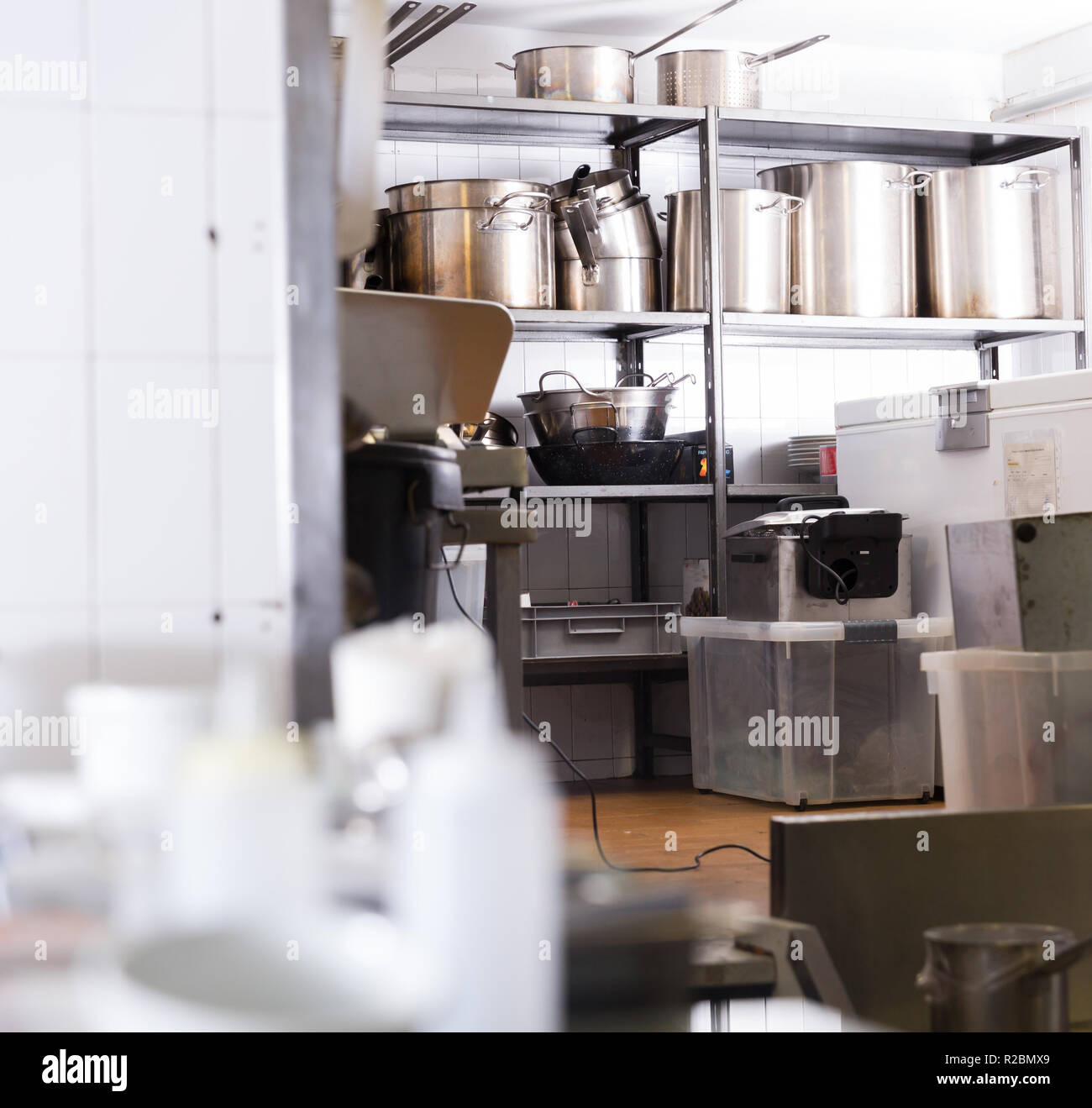 Utensils on metal rack in commercial kitchen Stock Photo - Alamy