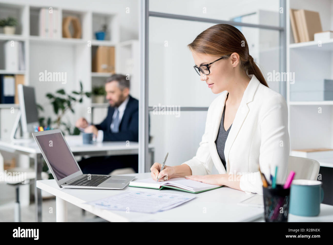 Serious lady making notes in diary Stock Photo