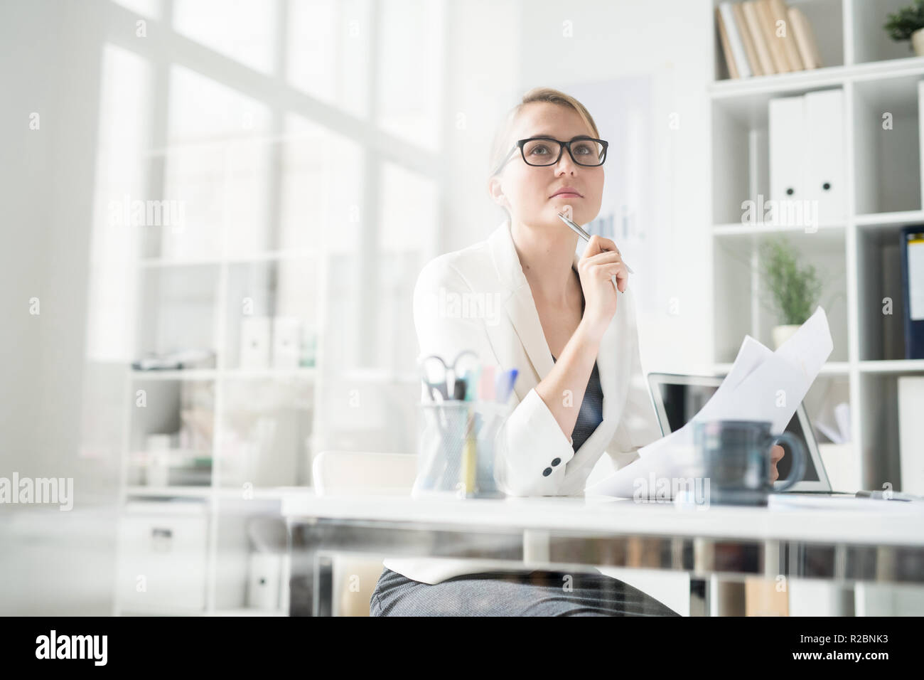 Pensive lady working with papers in office Stock Photo