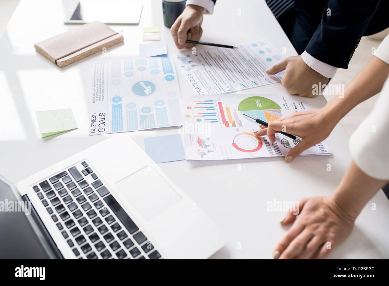 Discussing marketing data at meeting Stock Photo Alamy