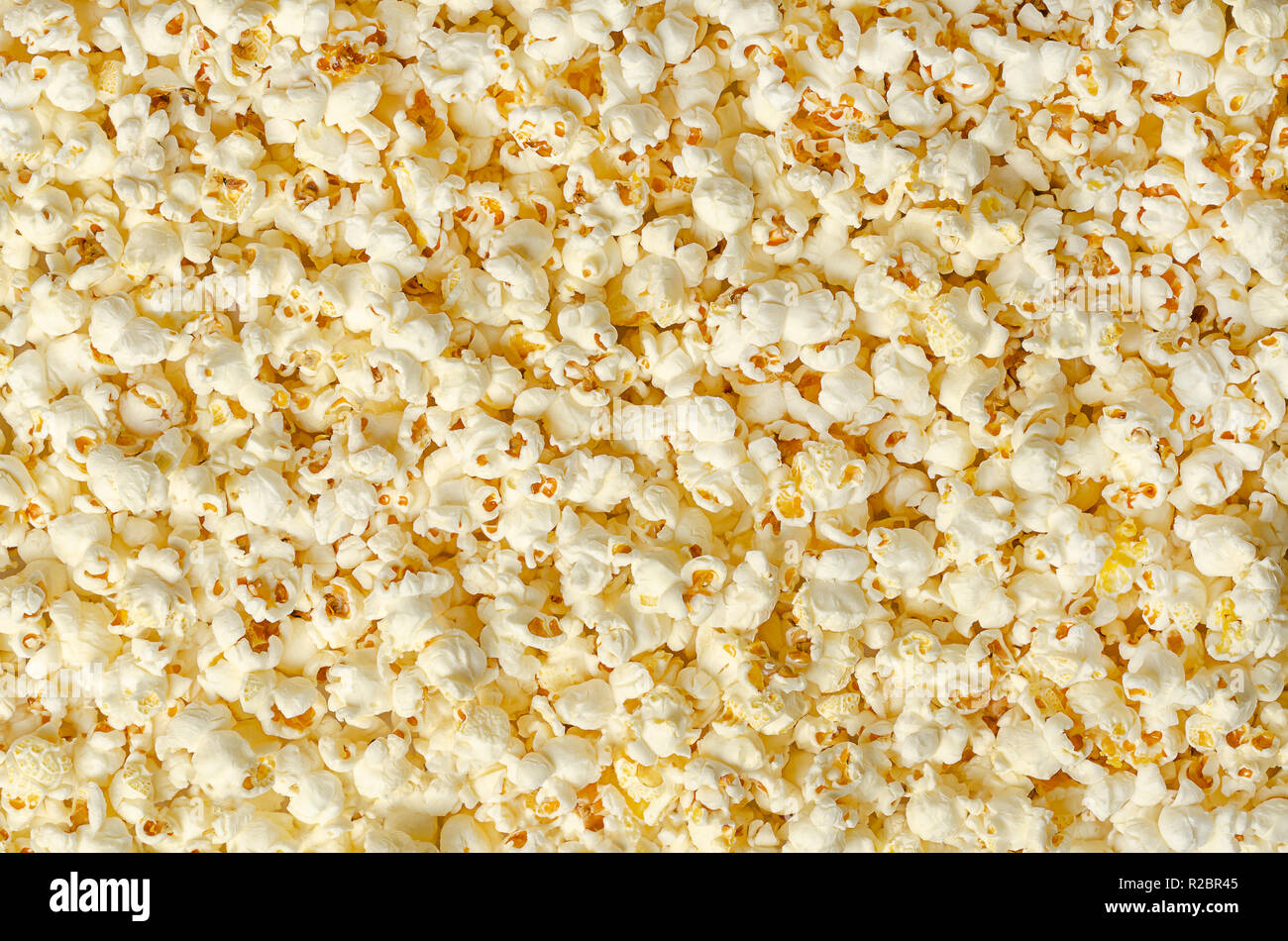 Popcorn, popped corn, surface and background. Butterfly shaped popcorn puffed up from the kernels, after it has been heated. Stock Photo
